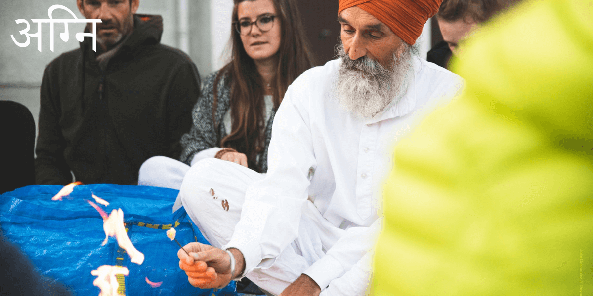 Atma Singh dispose du ghee sur le feu pour accomplir le rituel Agni Hotra