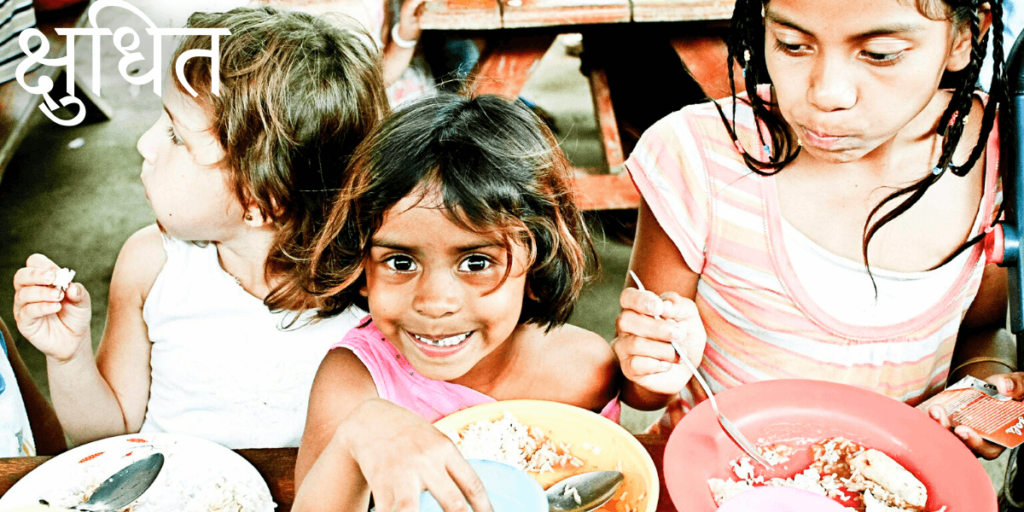 Une petite fille pétillante à table en train de manger.